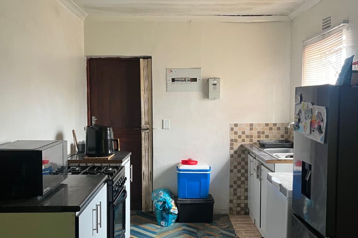 A functional kitchen featuring built-in cabinetry, a gas stove, and a tiled backsplash, requiring cosmetic updates to the ceiling and finishes.