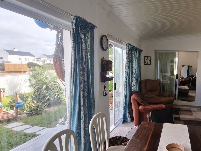 A covered patio area featuring sliding glass doors that provide access to the garden and allow for natural light.