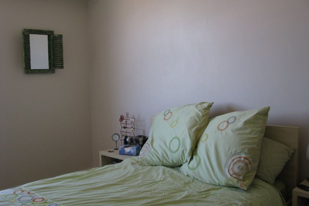 A simple bedroom interior featuring neutral walls and standard finishes, providing a functional space for rest.