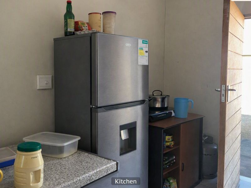 A compact kitchen area featuring a laminate countertop and basic utility space, suitable for efficient meal preparation.