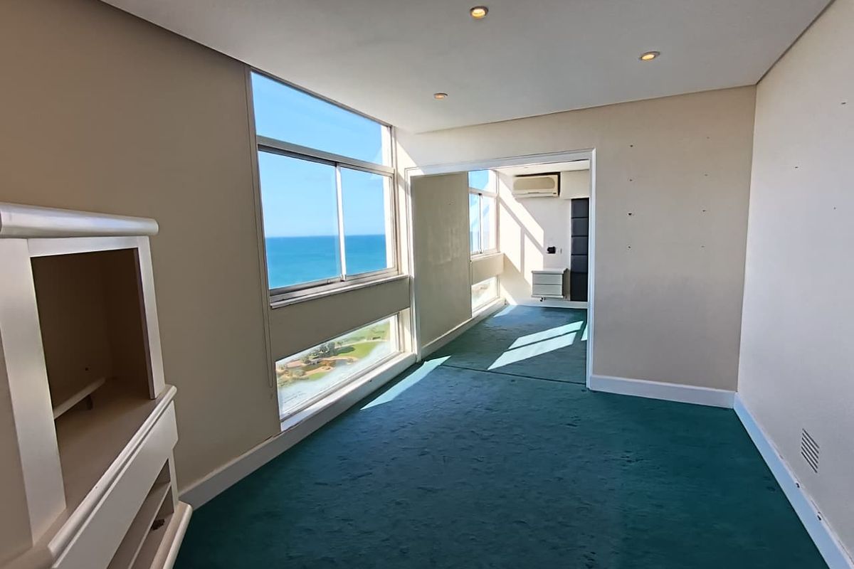 An empty bedroom featuring large windows with ocean views, recessed lighting, and an integrated air conditioning unit.