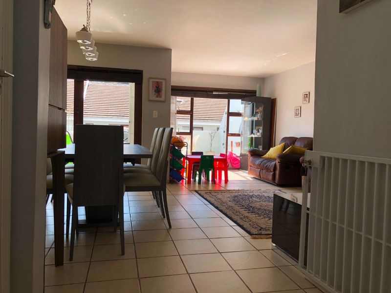 Open-plan living and dining area featuring tiled flooring and large sliding glass doors providing access to the outdoor space.