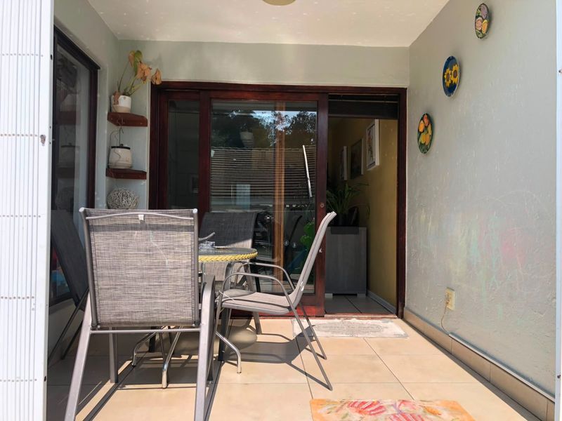 A covered patio area featuring tiled flooring and sliding glass doors providing access to the interior living space.