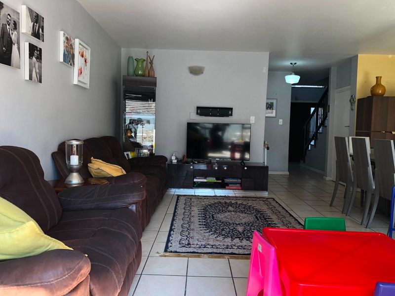 Open plan living area featuring tiled flooring and a staircase leading to the upper level, providing a functional and connected living space.