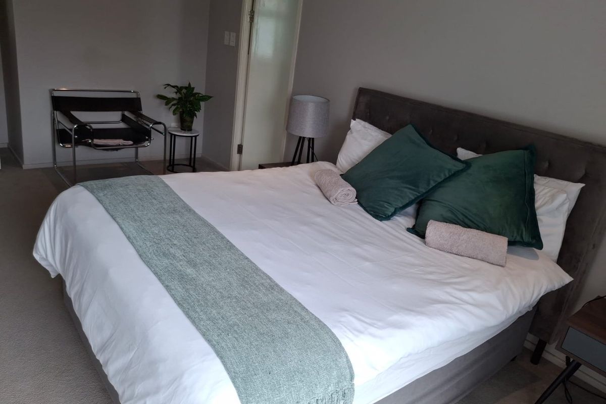 A well-maintained bedroom featuring neutral wall tones and carpeted flooring, providing a comfortable and functional living space.