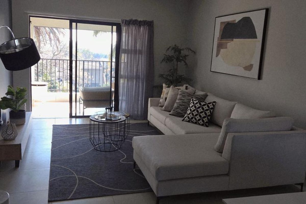 A well-lit living room featuring tiled flooring and a sliding glass door that provides direct access to an outdoor balcony area.