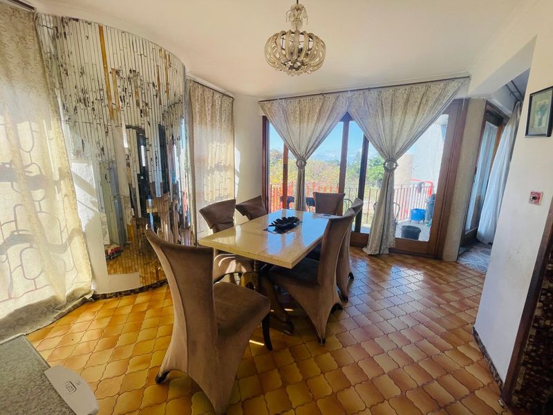 Dining room featuring tiled flooring, a unique curved mirrored wall, and sliding glass doors providing access to an outdoor area.