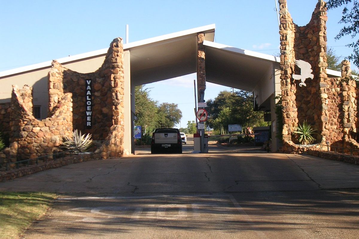 The entrance gatehouse to the Vaaloewer estate, featuring distinctive stone masonry pillars and a secure access boom gate.
