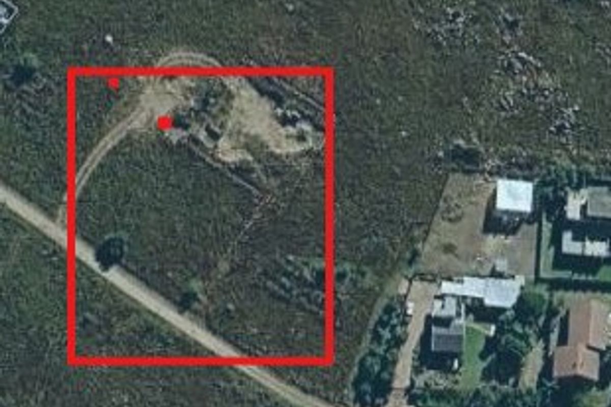 Aerial view of a vacant residential plot with access road, highlighting the property boundaries and surrounding landscape.