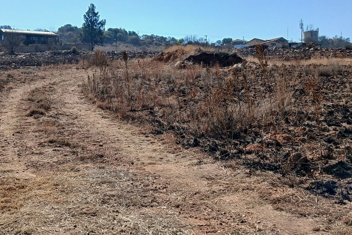 A view of the vacant residential land showing the natural terrain and existing dirt access path.
