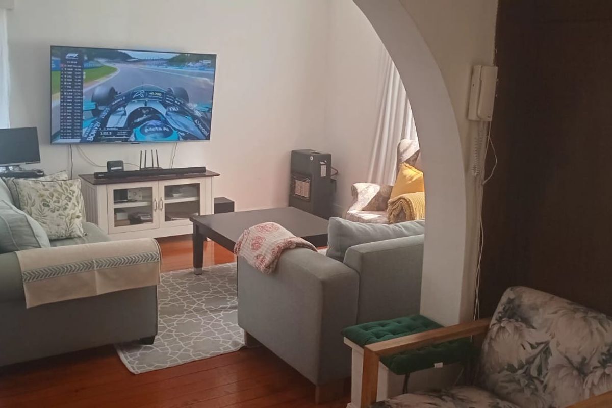 A comfortable living room featuring hardwood flooring and a distinctive arched doorway, providing a warm and inviting atmosphere.
