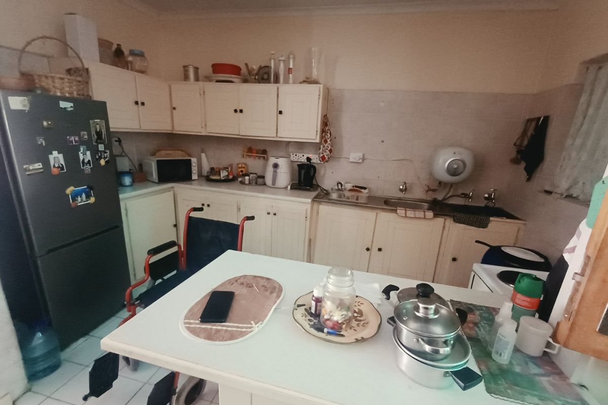 A dated kitchen featuring original cabinetry, tiled splashbacks, and a functional layout, offering significant potential for modernization and renovation.
