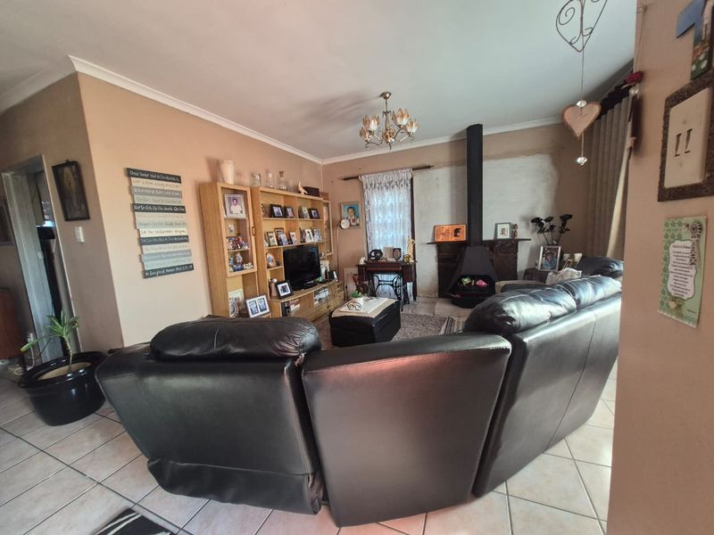 Living room featuring a freestanding fireplace, ceramic tiled flooring, and decorative coving, offering a comfortable space for relaxation.