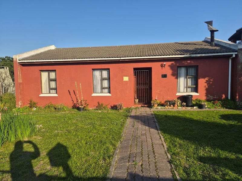 Front elevation of a single-story house featuring a brick paved walkway, concrete tiled roof, and security gate entrance.