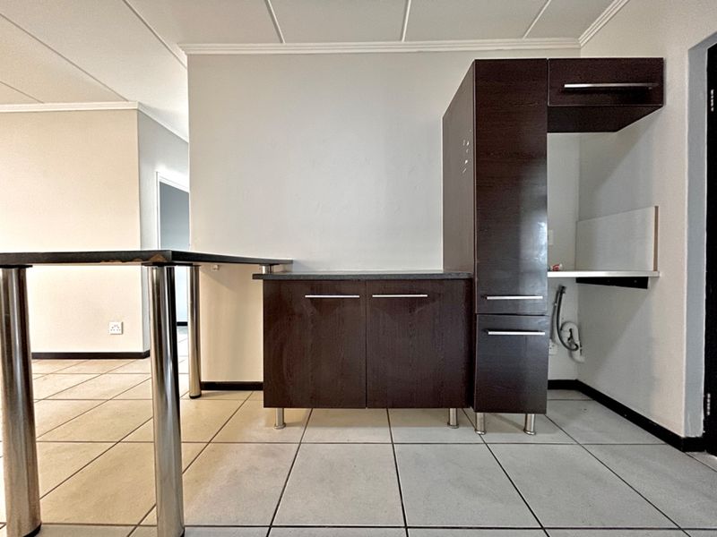 A functional kitchen area featuring dark wood cabinetry, a breakfast bar, and tiled flooring, offering a blank canvas for modern updates.