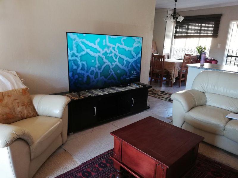 Open plan living and dining area featuring tiled flooring, natural light through window blinds, and a connected layout suitable for family living.