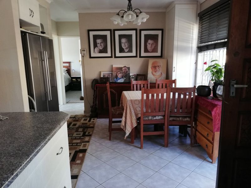 Open plan dining area featuring tiled flooring, built-in cabinetry, and granite countertops, providing a functional space adjacent to the kitchen.
