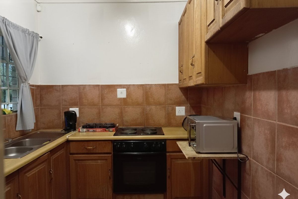 A functional kitchen featuring wooden cabinetry, a built-in oven with electric hob, and a double bowl sink with tiled backsplash.