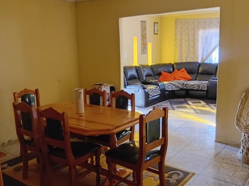 Open plan living and dining area featuring tiled flooring and neutral wall finishes, providing a functional layout for family living.
