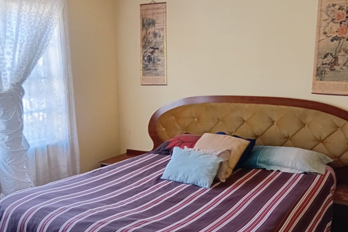A bedroom featuring neutral walls with visible surface imperfections and coving detail, requiring cosmetic updates to improve the overall finish.