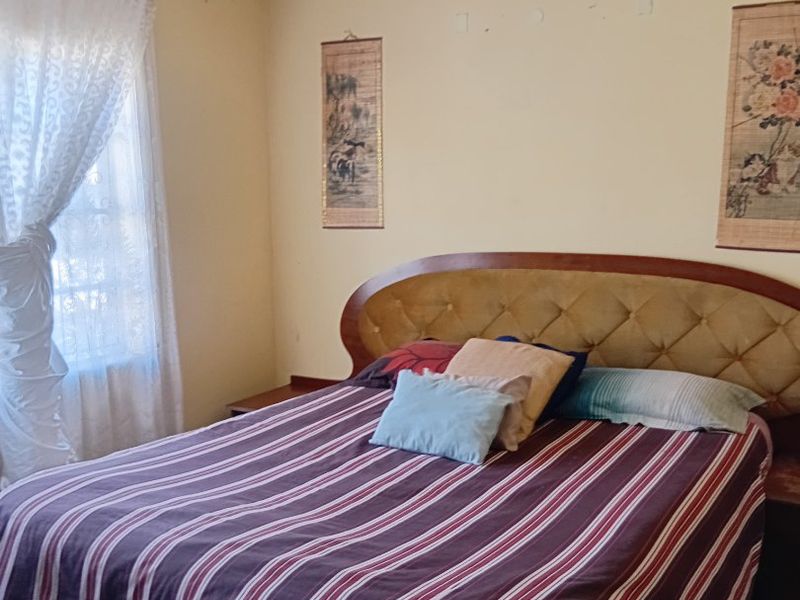 A bedroom featuring neutral walls with visible surface imperfections and coving detail, requiring cosmetic updates to improve the overall finish.