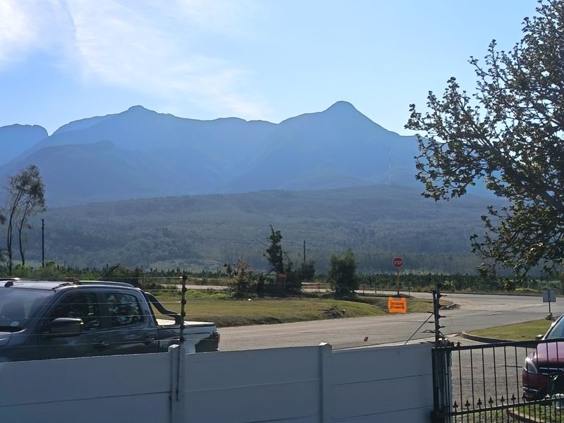 A scenic view of the surrounding mountains and landscape from the property boundary.