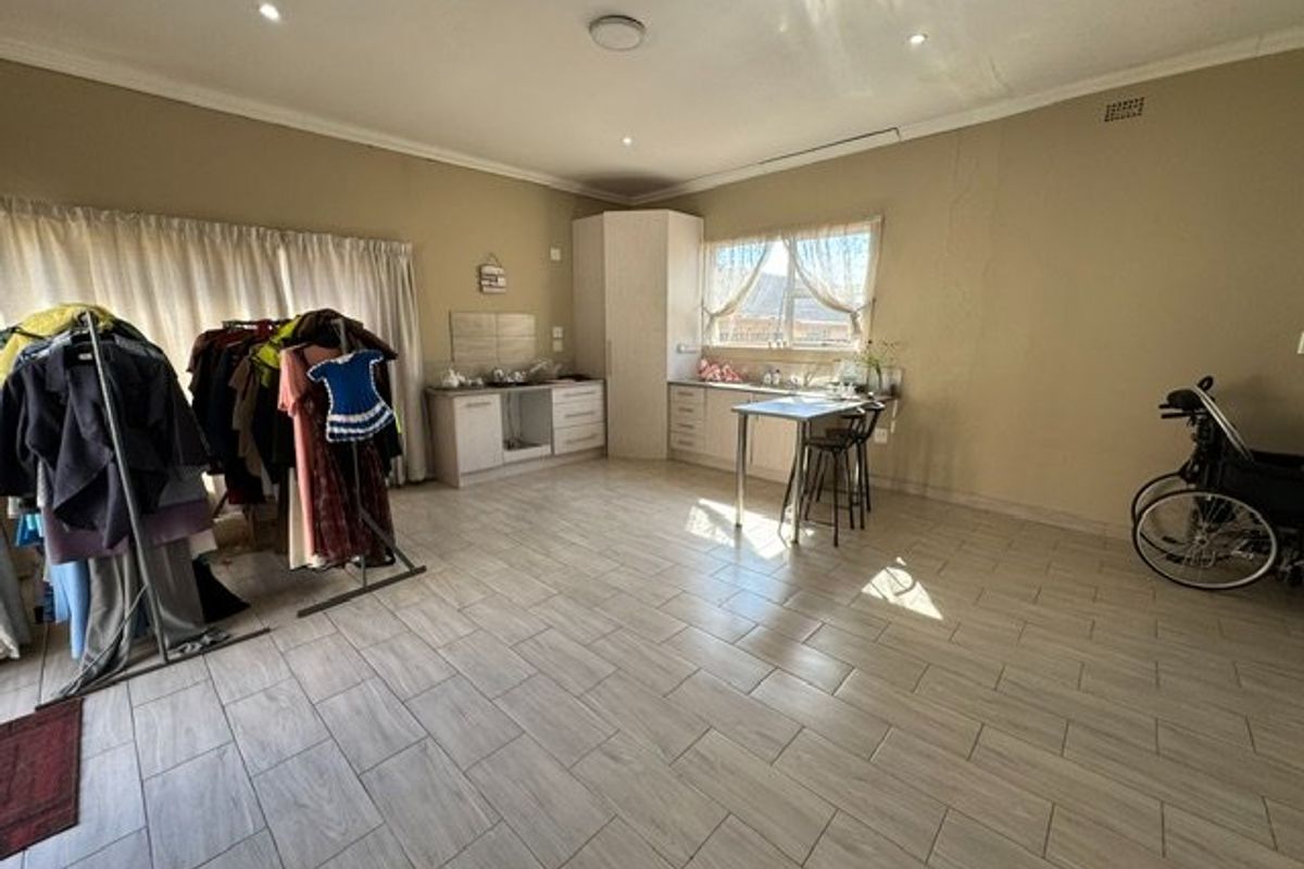 A functional kitchen area featuring tiled flooring, built-in cabinetry, and a sink, offering a blank canvas for potential updates or modern styling.