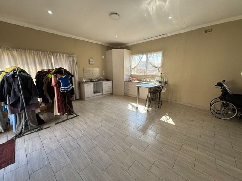 A functional kitchen area featuring tiled flooring, built-in cabinetry, and a sink, offering a blank canvas for potential updates or modern styling.