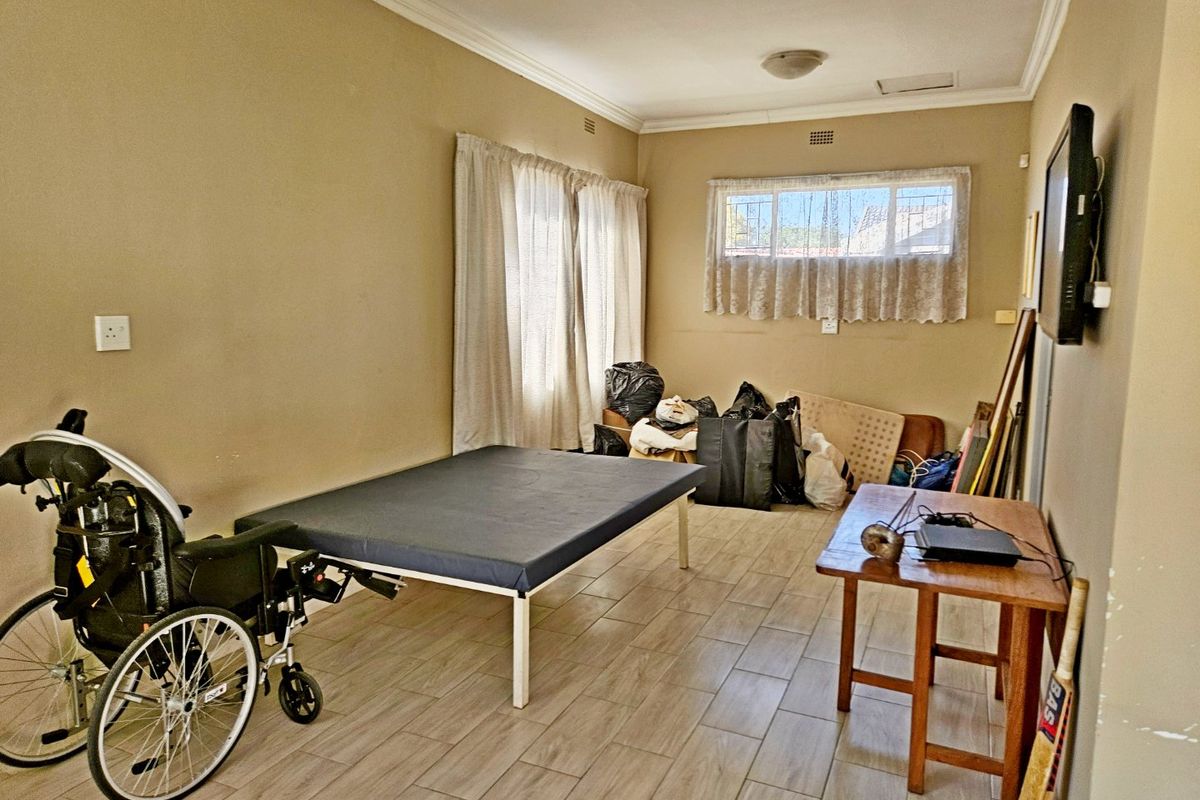 A bedroom featuring tiled flooring and security bars on the window, offering a functional space ready for personalization.