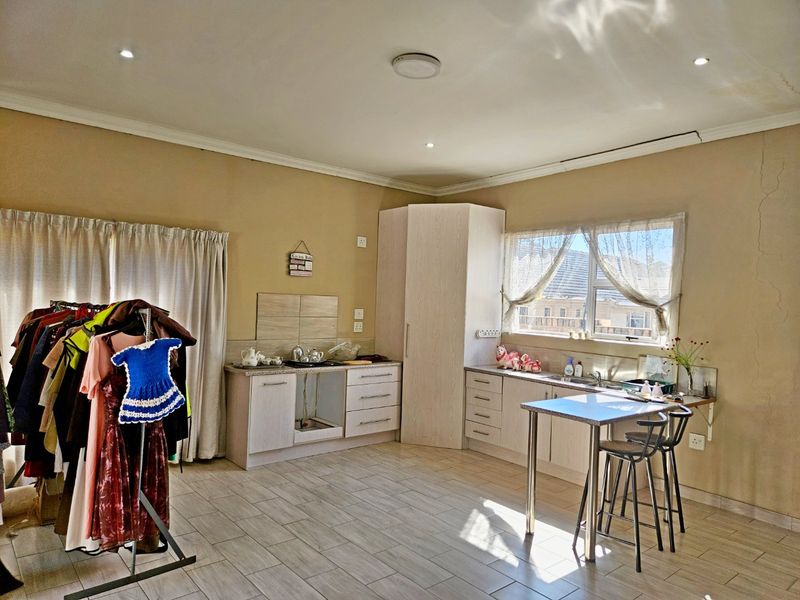 A kitchen area featuring tiled floors, built-in cabinetry, and a corner pantry unit, currently requiring repairs to cabinetry and wall finishes.