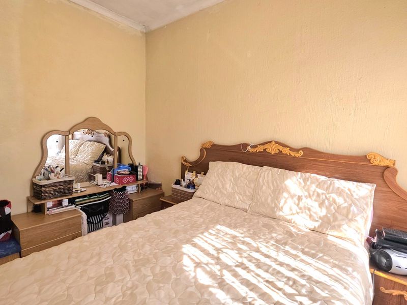 A bedroom featuring a dated aesthetic with textured walls and visible ceiling wear, offering a blank canvas for modernization and interior updates.