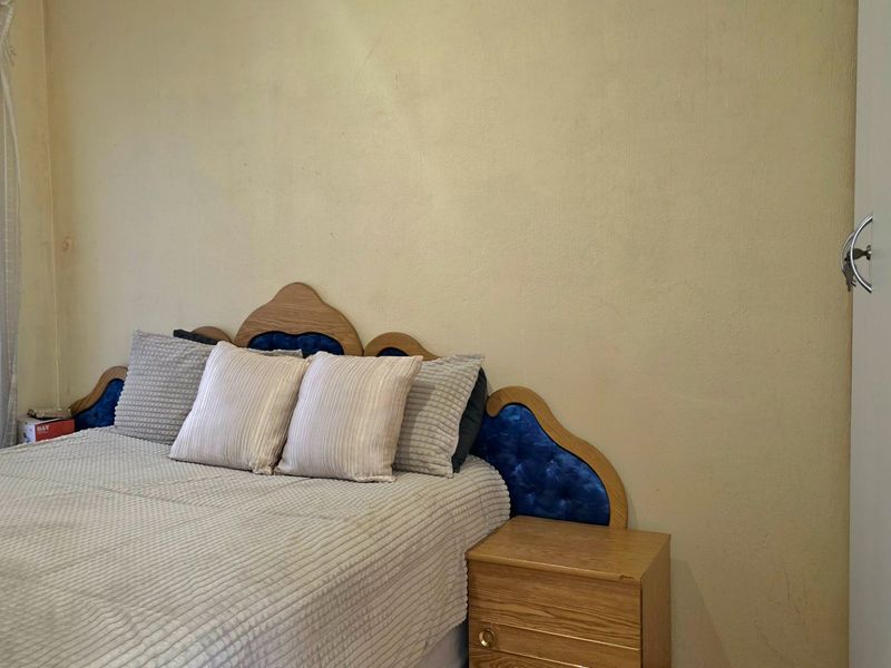 A bedroom featuring a built-in wardrobe and neutral wall finishes, offering a functional space ready for cosmetic updates.