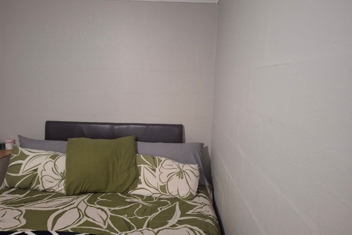 A simple bedroom corner featuring painted block walls and a cove cornice finish.