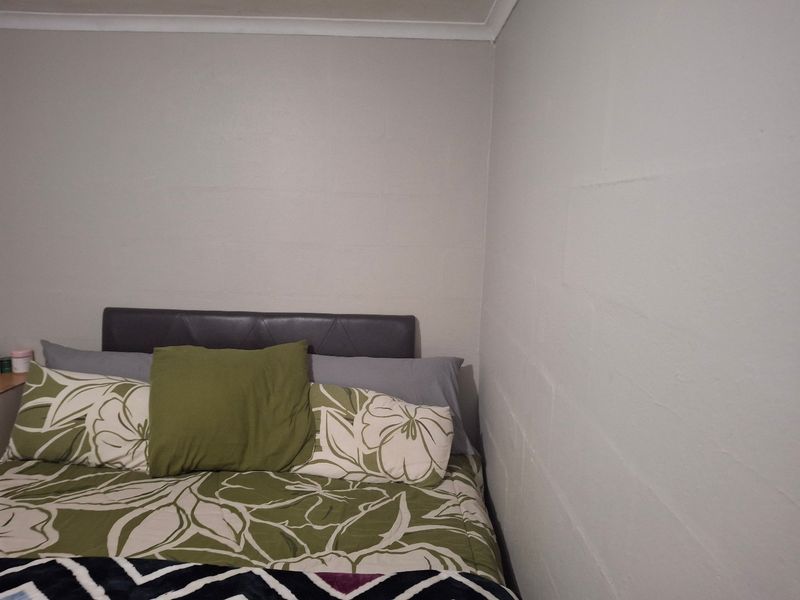 A simple bedroom corner featuring painted block walls and a cove cornice finish.