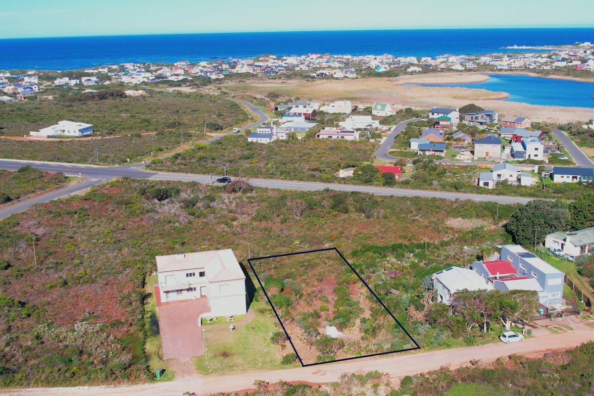 Aerial view of a vacant residential plot situated in a coastal neighborhood, highlighting the property boundaries and surrounding landscape.