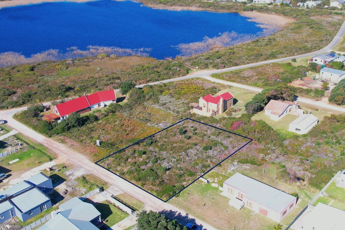 Aerial view of a vacant residential plot situated in a coastal area, highlighting the property boundaries and surrounding landscape.