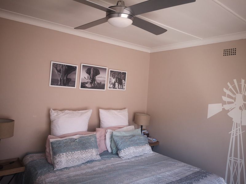 A well-maintained bedroom featuring a modern ceiling fan, coving, and neutral wall tones, providing a comfortable and functional living space.