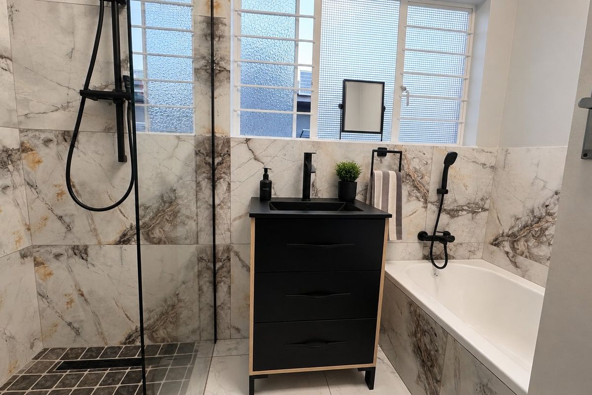 Modern bathroom featuring marble-look wall tiles, a walk-in shower, a bathtub, and a sleek black vanity with matching matte black fixtures.