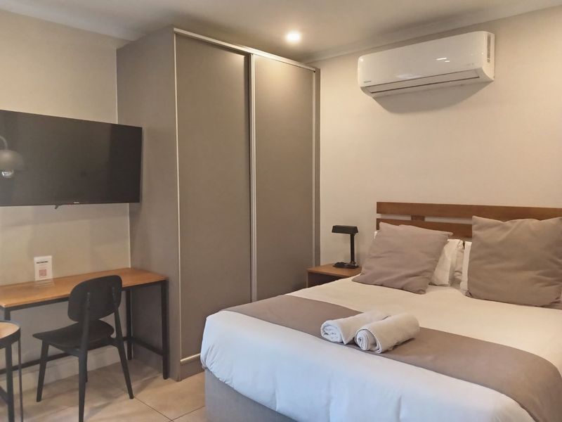 A well-maintained bedroom featuring a built-in wardrobe, split-system air conditioning, and neutral finishes, providing a comfortable and functional living space.