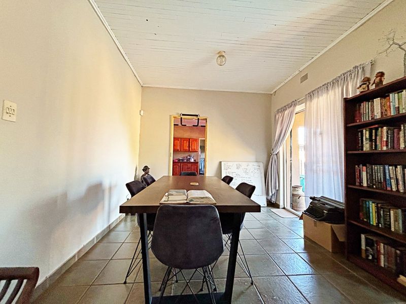 A dining room featuring tiled flooring, a timber plank ceiling, and a sliding glass door providing access to the exterior.