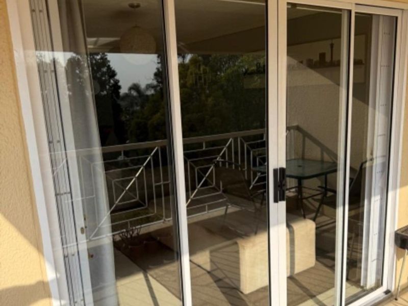 A covered balcony featuring white-framed sliding glass doors and a decorative metal balustrade, providing an outdoor transition space.