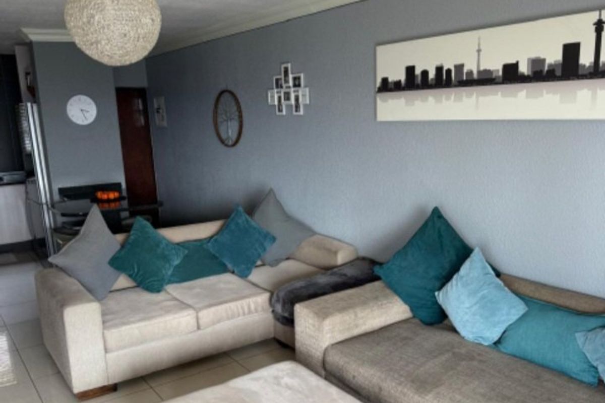 A comfortable living room featuring tiled flooring, coved ceilings, and neutral wall tones, providing a functional and inviting space for relaxation.