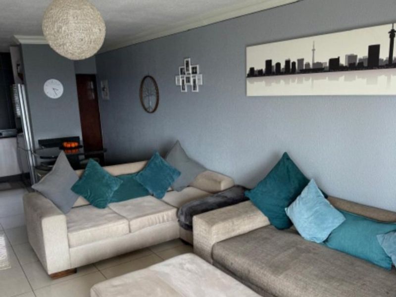 A comfortable living room featuring tiled flooring, coved ceilings, and neutral wall tones, providing a functional and inviting space for relaxation.