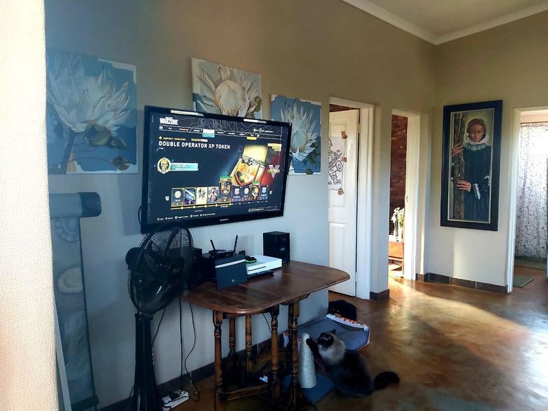 A living area featuring polished concrete floors and multiple internal doorways, providing access to other parts of the apartment.