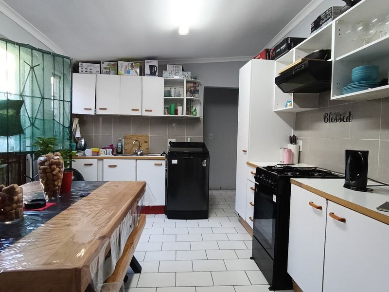 A functional kitchen featuring white cabinetry, tiled backsplash, tiled flooring, and a gas stove, providing a practical workspace for cooking and meal preparation.