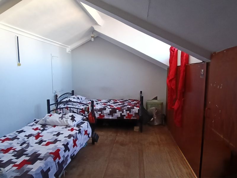 Attic-style bedroom featuring a sloped ceiling with exposed rafters and a built-in wooden wardrobe.