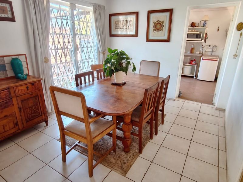 Dining room featuring tiled flooring and a sliding glass door with security gate, providing access to the exterior.