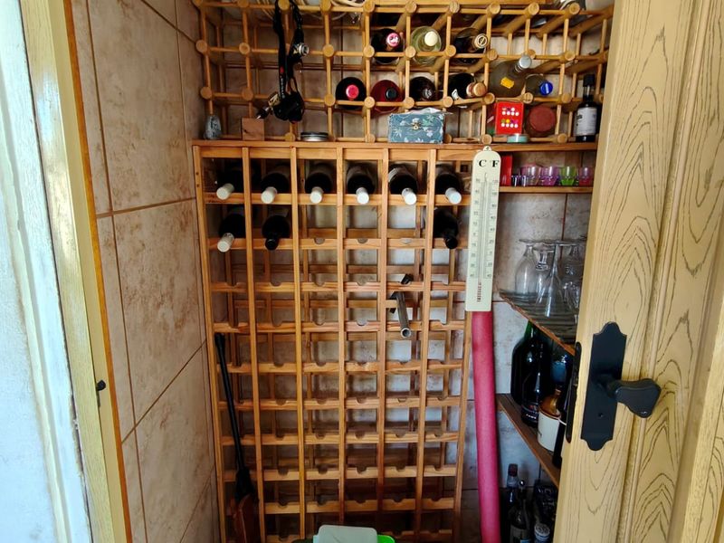 A dedicated wine storage area featuring built-in timber wine racking and tiled wall finishes.