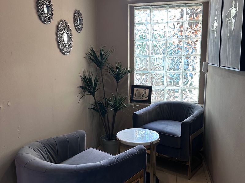 A cozy seating nook featuring a distinctive glass block window, tiled flooring, and modern pendant lighting.