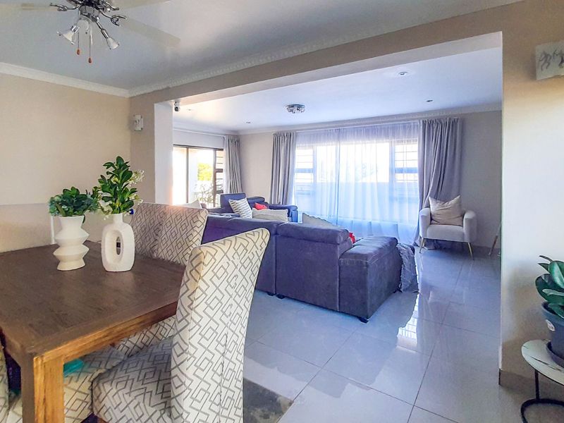 Spacious open-plan living and dining area featuring polished tiled flooring, recessed lighting, and large sliding doors providing ample natural light.